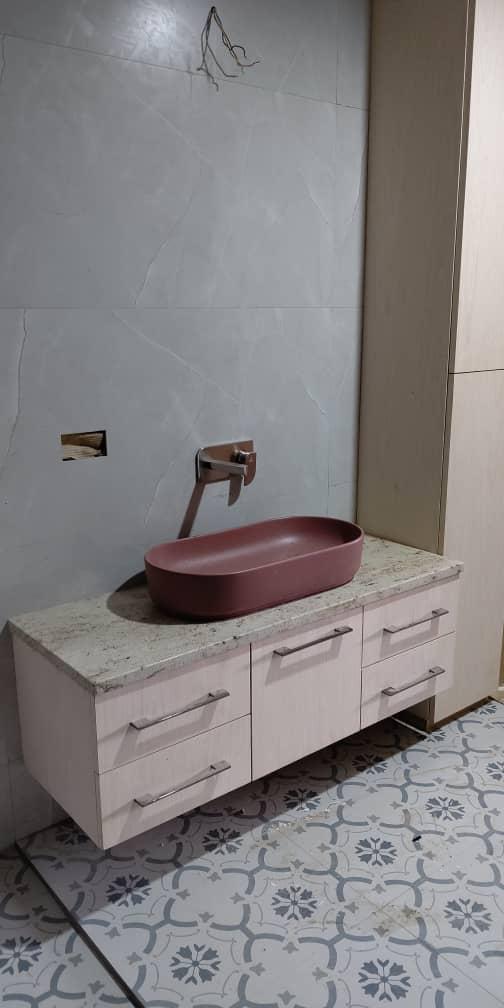 Floating vanity with designer vessel sink and patterned floor tiles