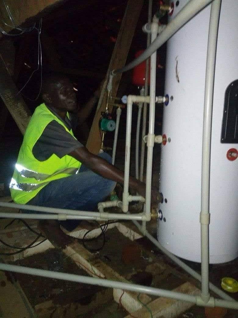 Latimtech technician installing solar boiler plumbing at night